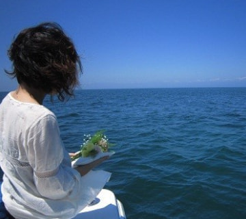 故人を想い海を見つめながら遺骨を抱く様子｜海洋散骨の基礎知識｜清蓮