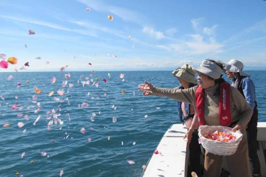 散骨クルーズで家族が花びらを海へ手向ける献花の様子
