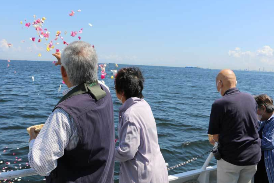 横須賀のプライベート散骨で、参加者が花びらを海に手向けている様子