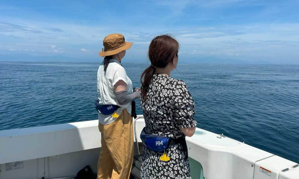 相模湾・葉山沖の合同散骨｜穏やかな海を前に、一組ずつ故人を見送るご家族の後ろ姿