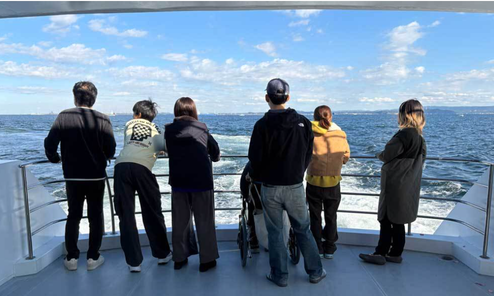 横須賀沖のプライベート散骨クルーズで、海を見つめながら静かに故人を見送るご家族。バリアフリー対応の船上で車椅子の方も安心して参加できる海洋散骨の様子