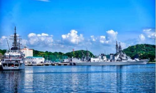 日米の艦船が並ぶ横須賀基地沖の港景色と静かな水面