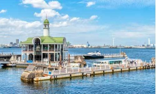 みなとみらいの街並みを背景に出航する、横浜を象徴する観光船の風景。