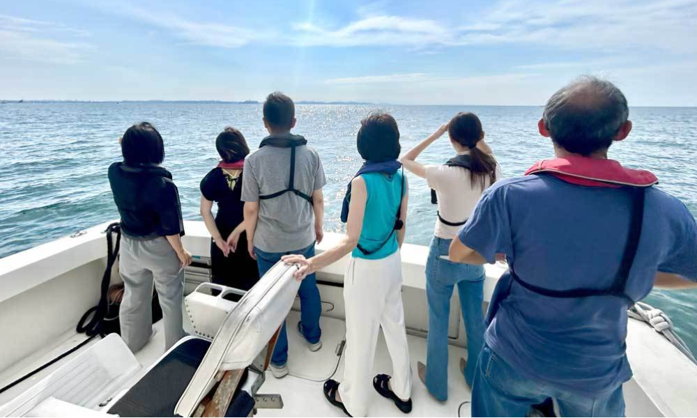 葉山沖のプライベート海洋散骨で海を見つめるご遺族の後ろ姿。静かな相模湾の上で、心を込めたお別れのひととき。