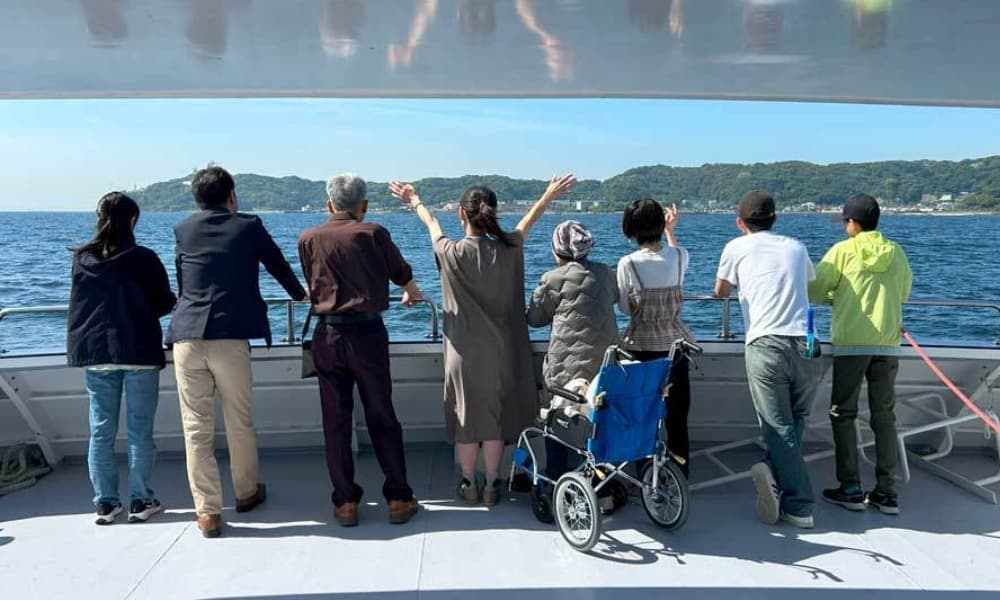 横須賀・観音崎沖での海洋散骨後、ご家族が故人に手を振りお別れしている様子。車椅子の方も安心して参加できるバリアフリー対応