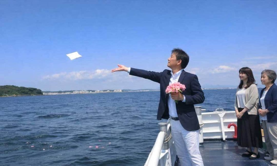 横須賀・猿島沖の合同散骨で、船上から故人を海へ見送るご家族の様子