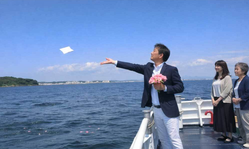 横須賀・猿島沖の合同散骨で、船上から故人を海へ見送るご家族の様子