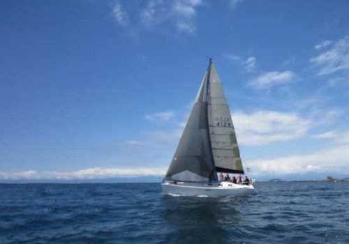 鎌倉沖を進むヨットと広がる青い海。湘南の自然に包まれた海洋散骨スポット