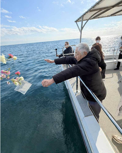 相模湾・湘南の海へ花を手向けながら散骨を行うご家族の様子