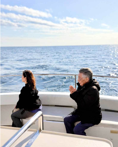 散骨後に船上で静かに手を合わせるご家族の様子