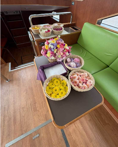 湘南の大型船内に飾られた色とりどりの献花と花びらのかご