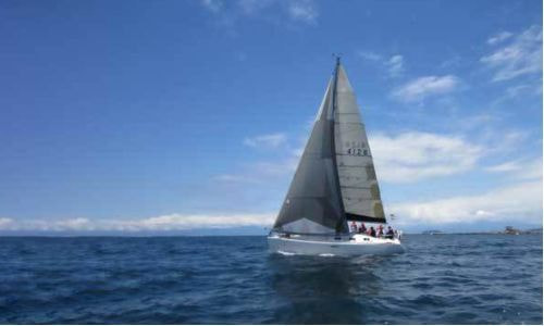 鎌倉沖を進むヨットと広がる青い海。湘南の自然に包まれた海洋散骨スポット