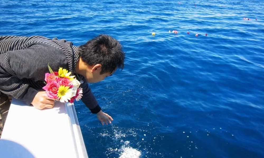 海洋散骨で花を手向けながら故人を見送るご家族
