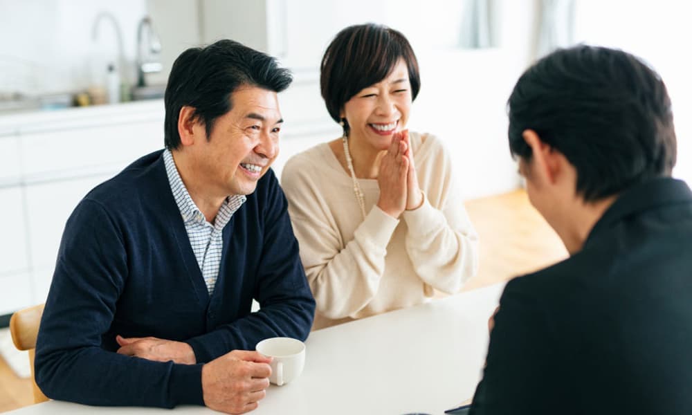 海洋散骨のプランや費用を担当スタッフに相談するご家族の様子