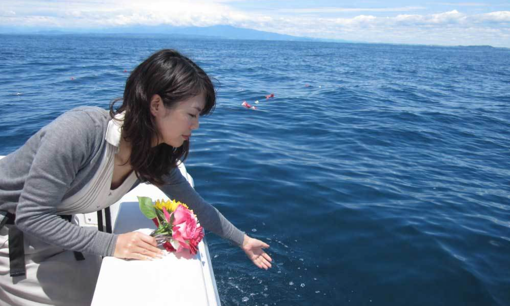 葉山沖の海洋散骨で、青く穏やかな相模湾に花とともにご遺骨をお見送りする様子