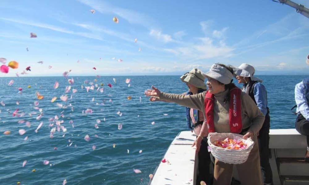 散骨クルーズで家族が花びらを海へ手向ける献花の様子