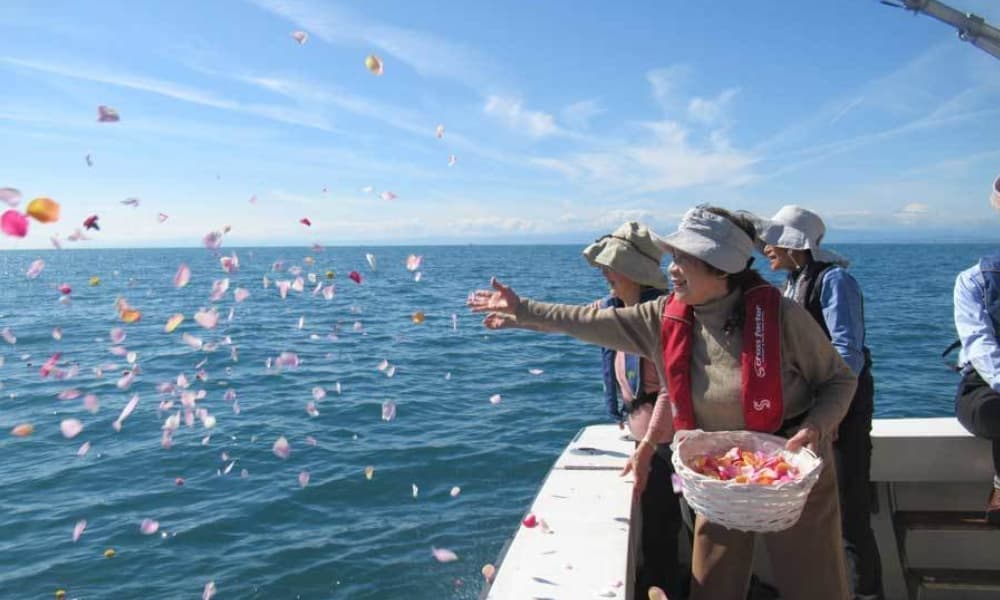 散骨クルーズで家族が花びらを海へ手向ける献花の様子