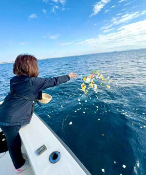 横浜ベイブリッジ沖で散骨後に献花を海へ手向ける様子